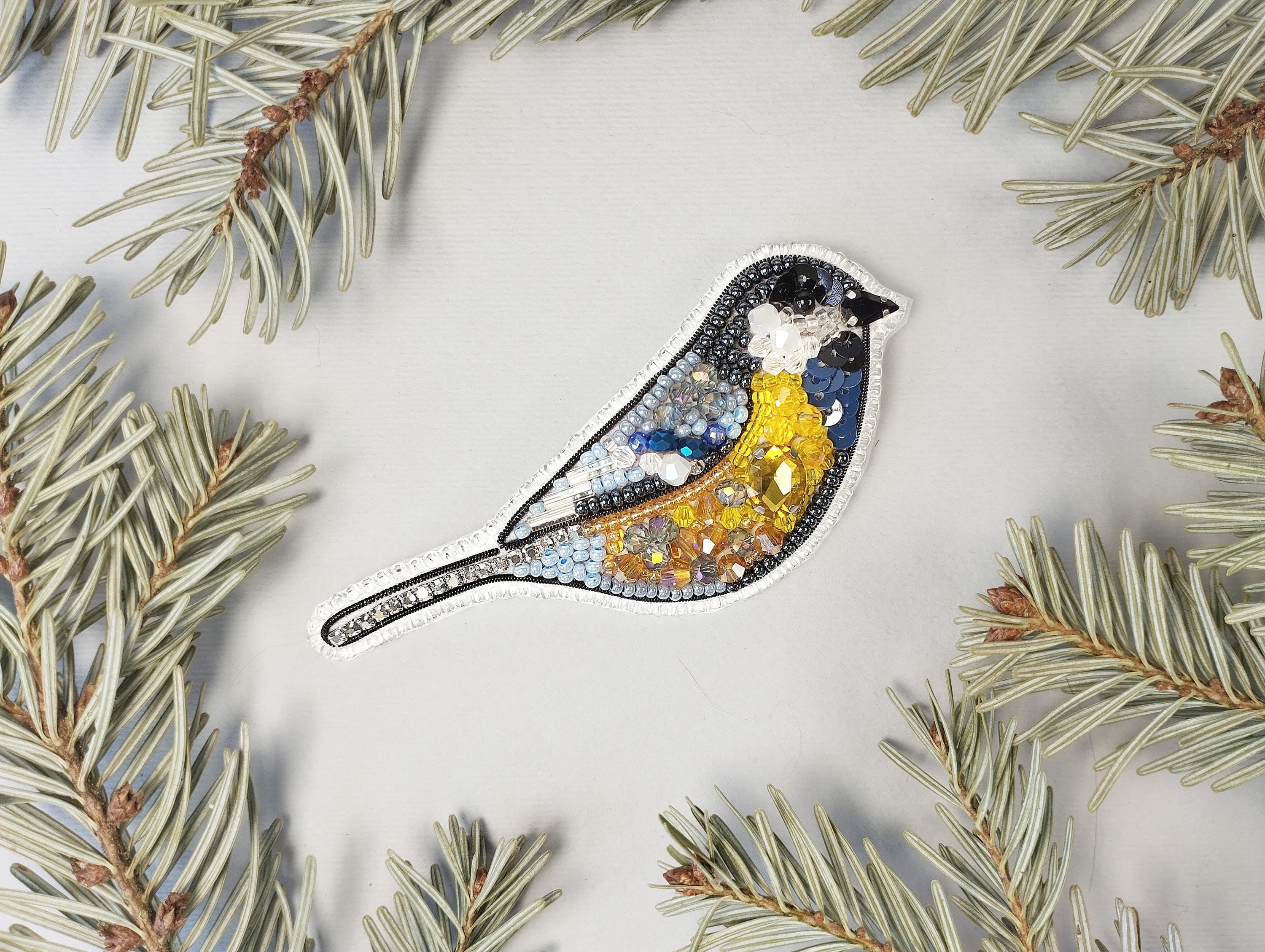 a blue bird sitting on top of a pine tree